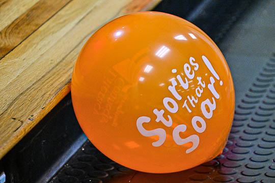 An orange balloon with print saying, Stories that Soar!
