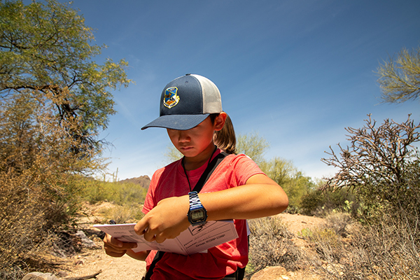 A student looks at his journal while on a hike